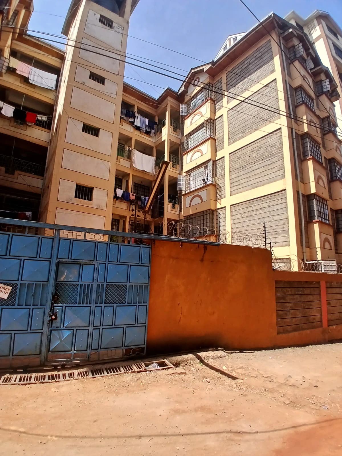 Multi-story residential building facade with compound gate