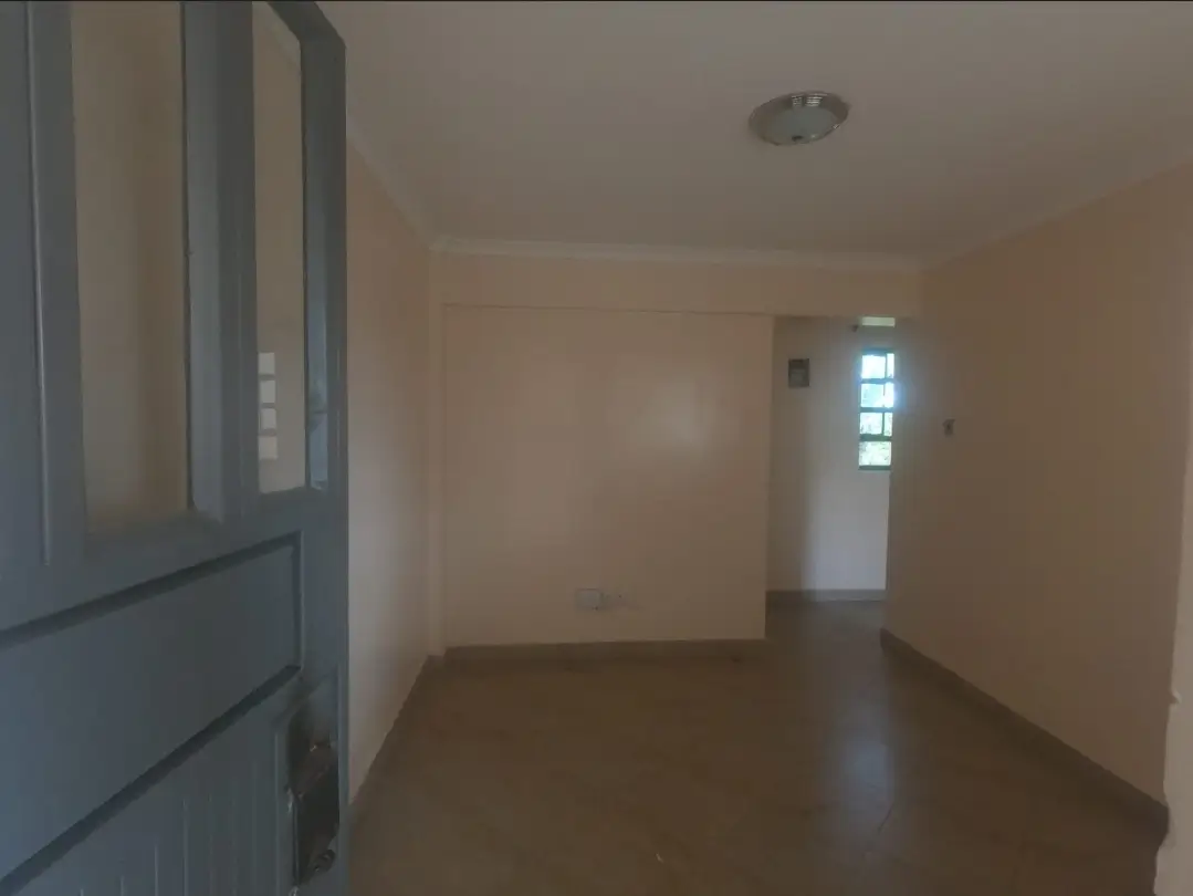 Empty living room with wooden flooring and natural light