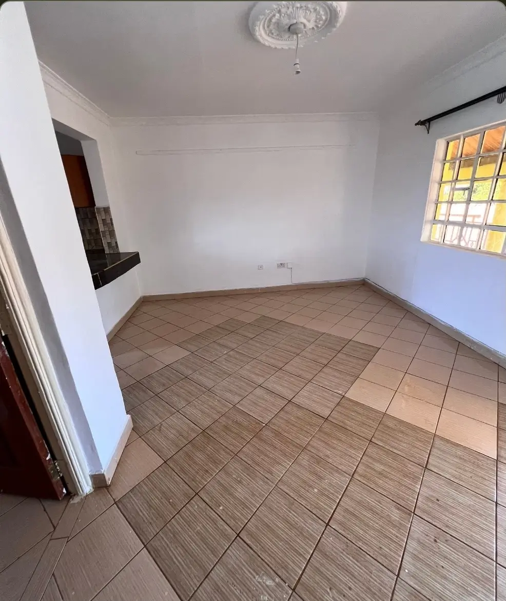 Unfurnished bedroom with terracotta tile flooring and natural light