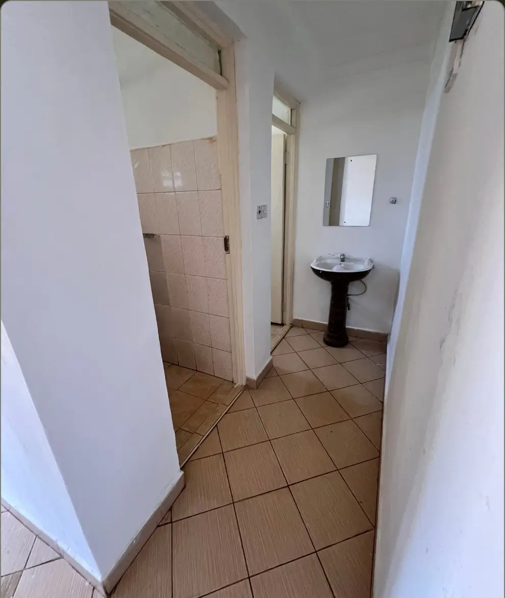 Compact bathroom with pedestal sink and tiled flooring