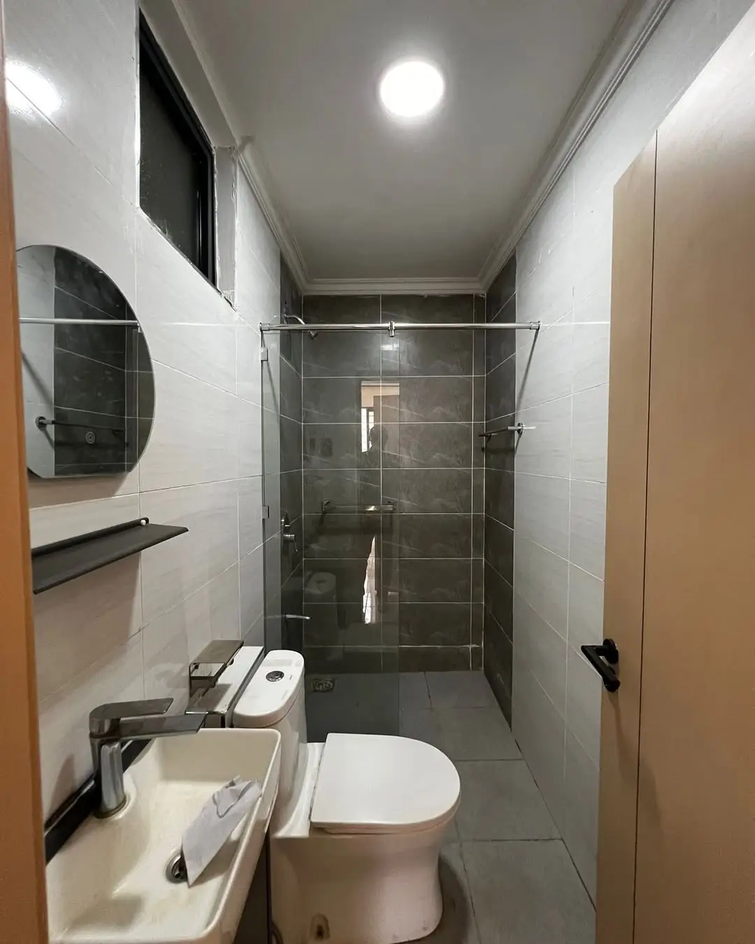 Modern bathroom with walk-in shower and dark tile accents