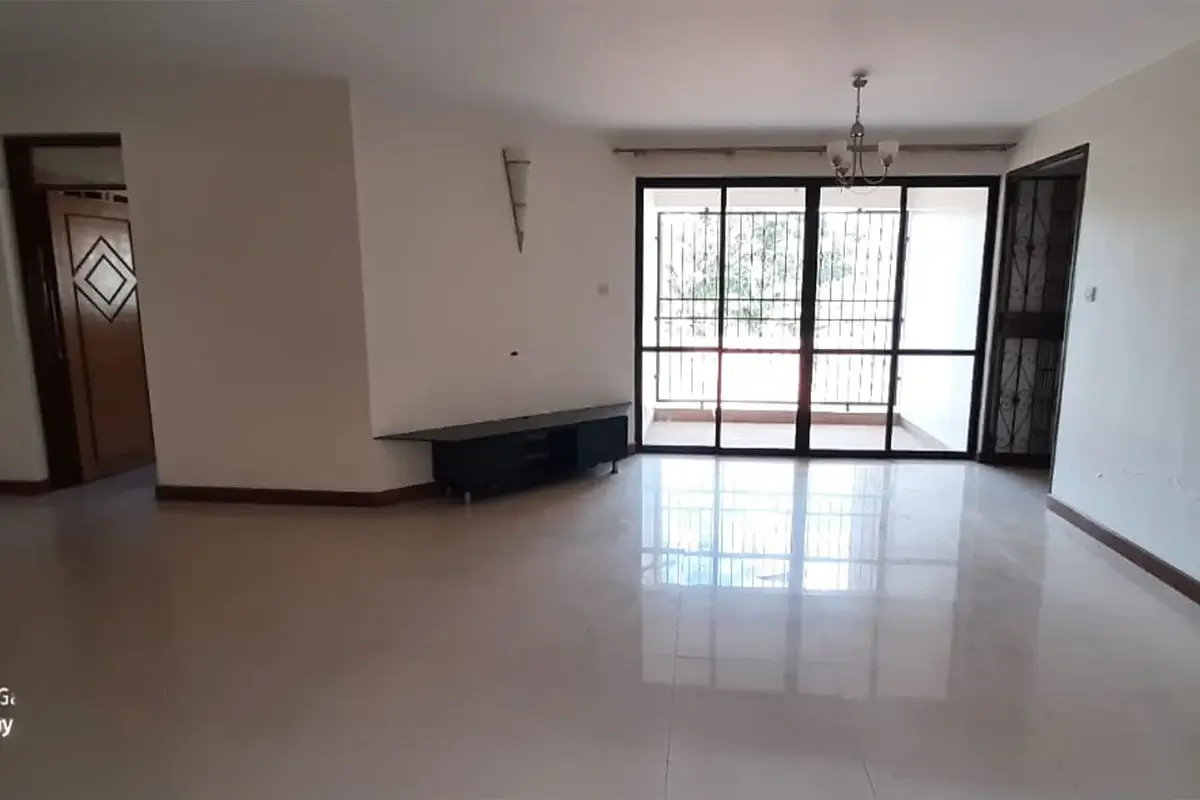Spacious empty living room with polished floors and glass doors.