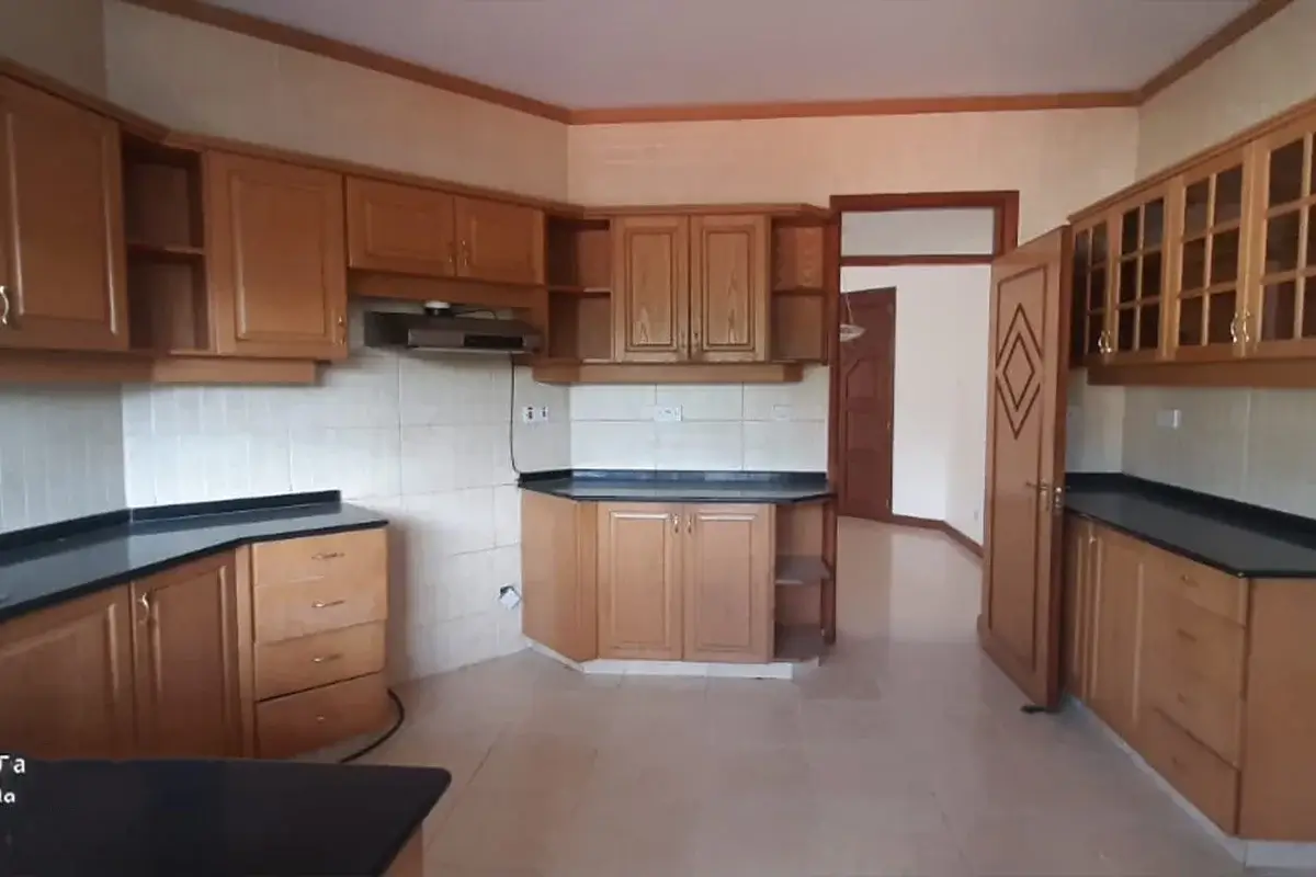 Spacious kitchen with wooden cabinets and black countertops