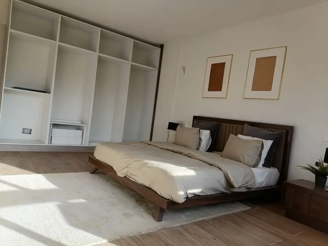 Master bedroom with built-in wardrobe and wooden bed frame