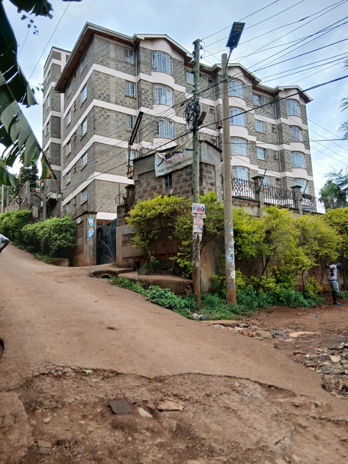Multi-story residential building with landscaped compound entrance