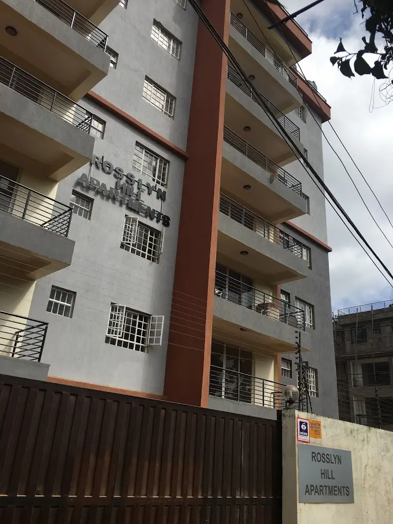 Multi-story apartment building facade with balconies and metal gate