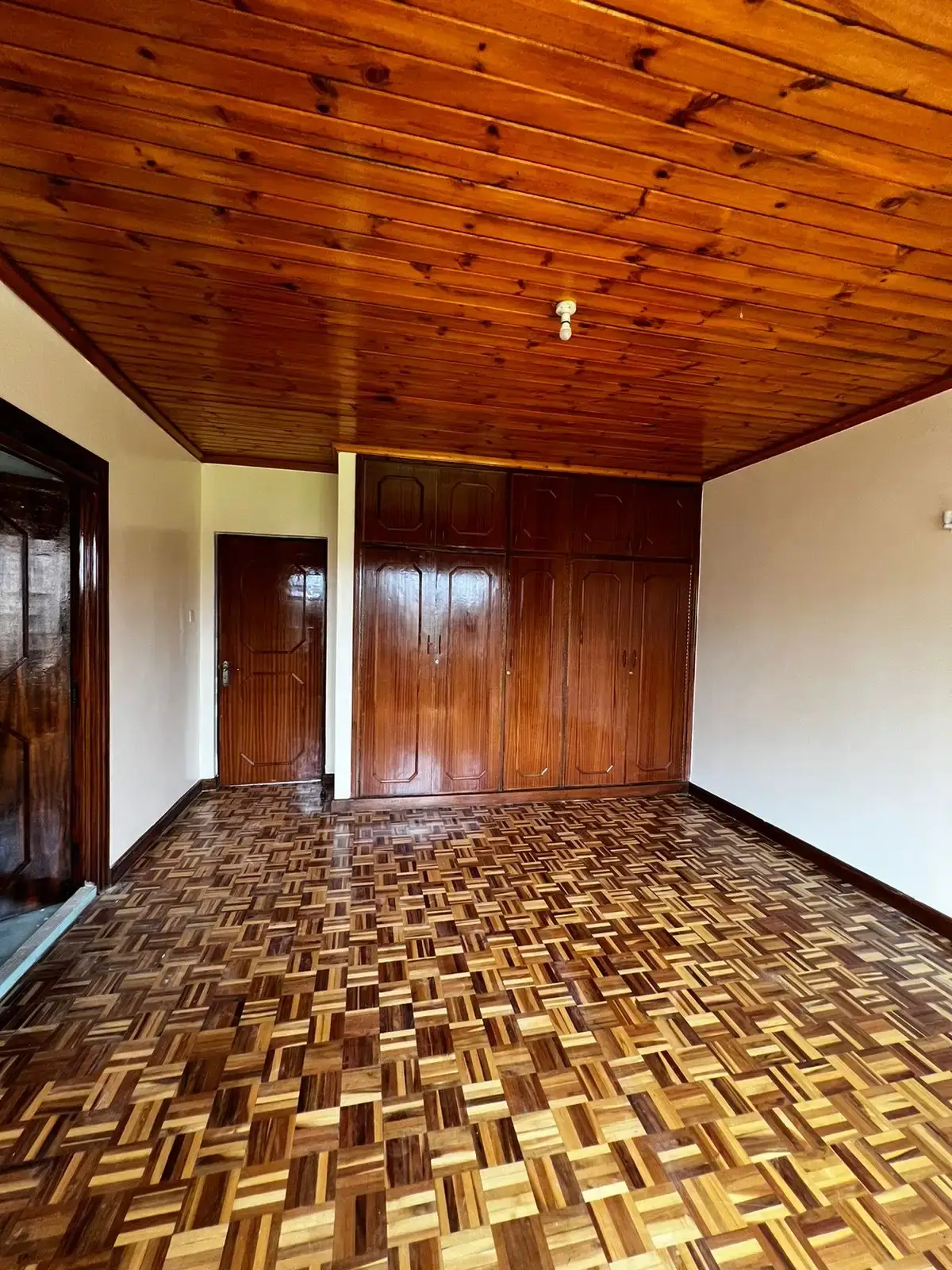 Spacious living area with wooden ceiling and parquet flooring