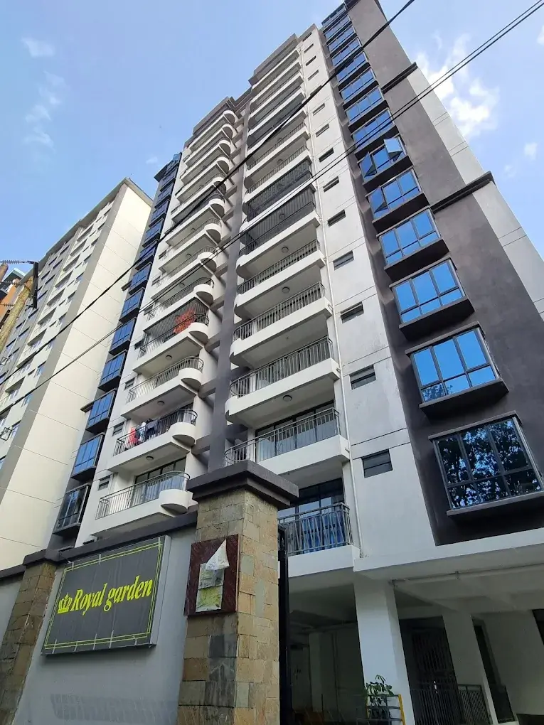 Modern multi-story residential building with balconies and street-level signage
