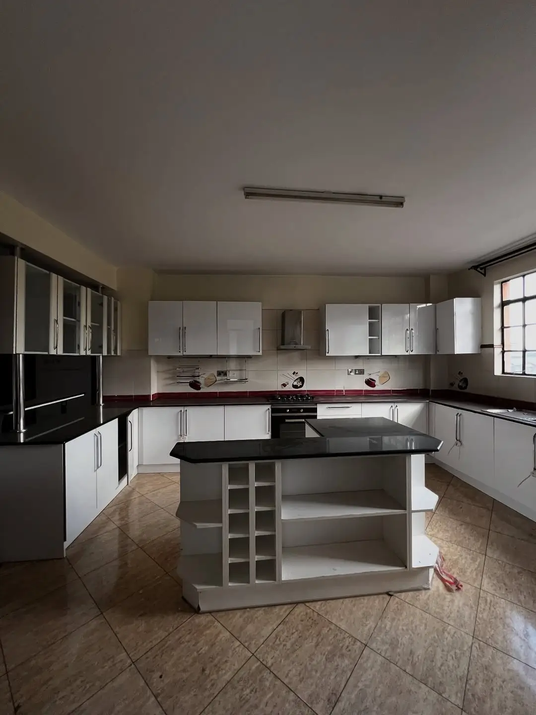 Modern kitchen with white cabinets, black island, stainless steel appliances