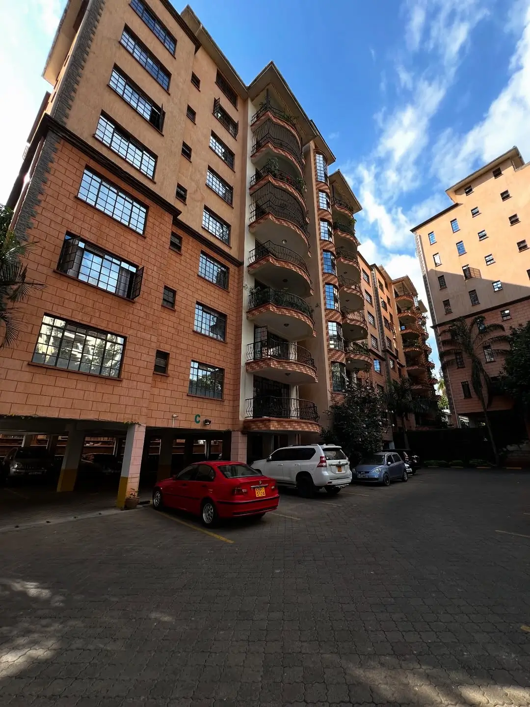 Multi-story residential building with ground-level parking bay