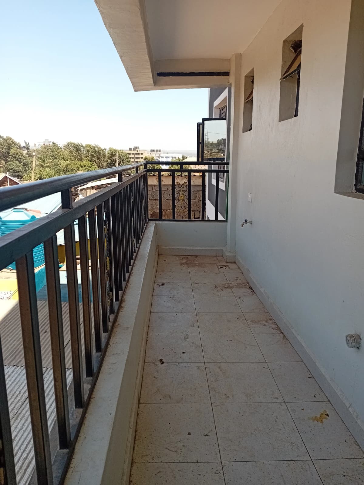 Spacious balcony with black railing and tiled flooring