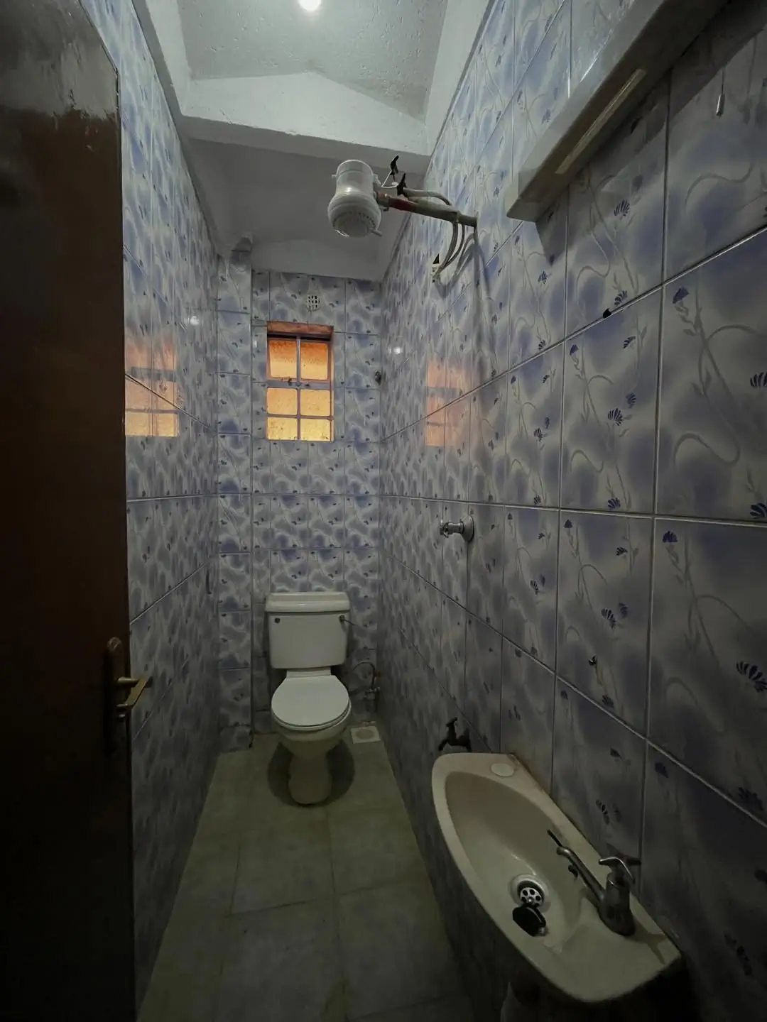 Compact bathroom with toilet, sink, and shower cubicle