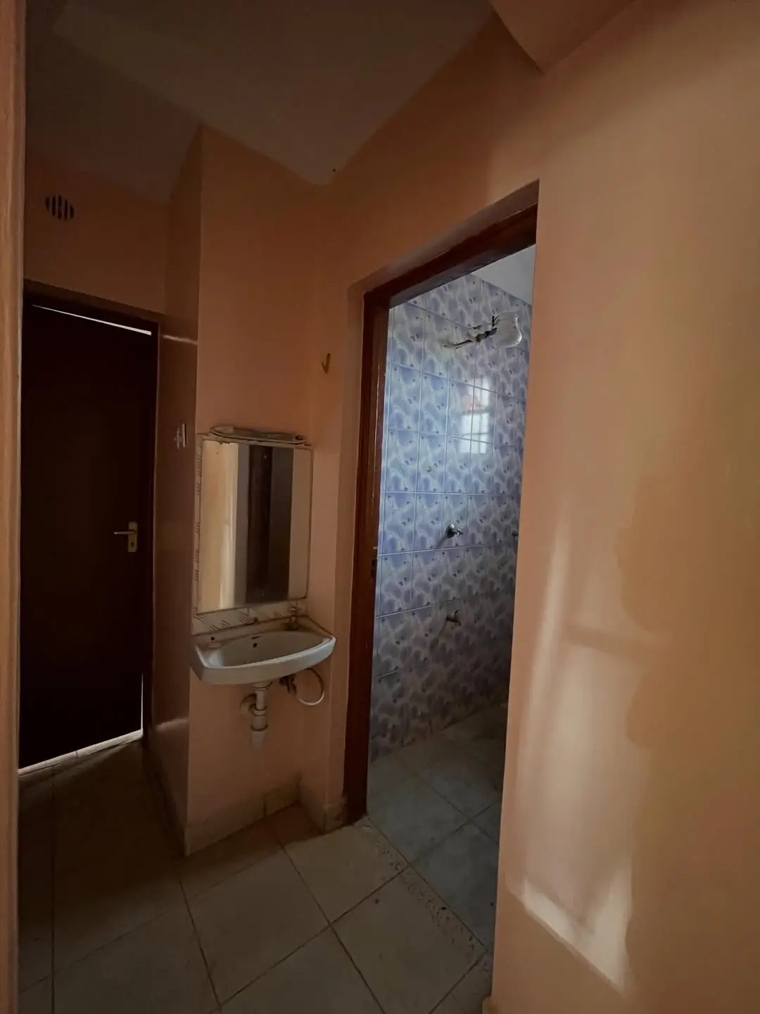 Bathroom with wall-mounted sink and tiled shower enclosure