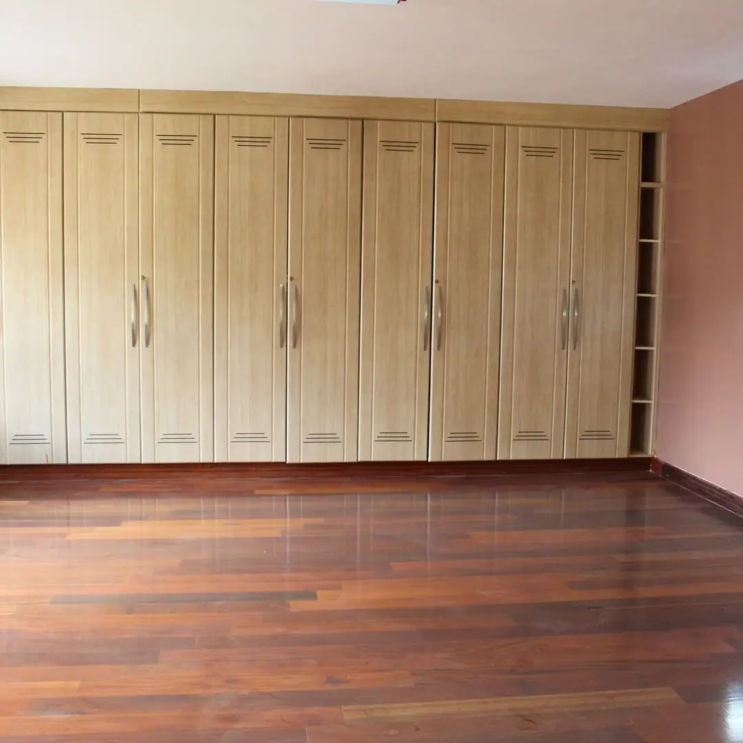 Spacious bedroom with built-in wooden wardrobe cabinetry
