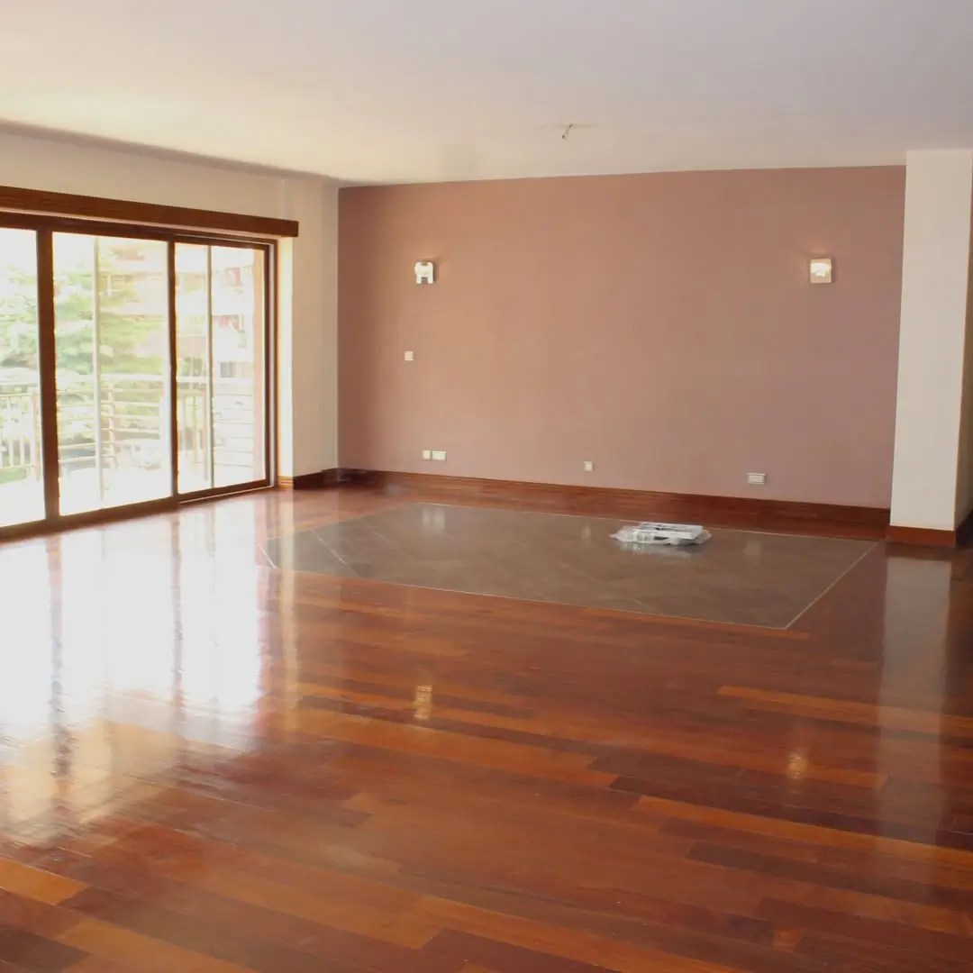 Spacious living room with polished wooden floors and glass doors