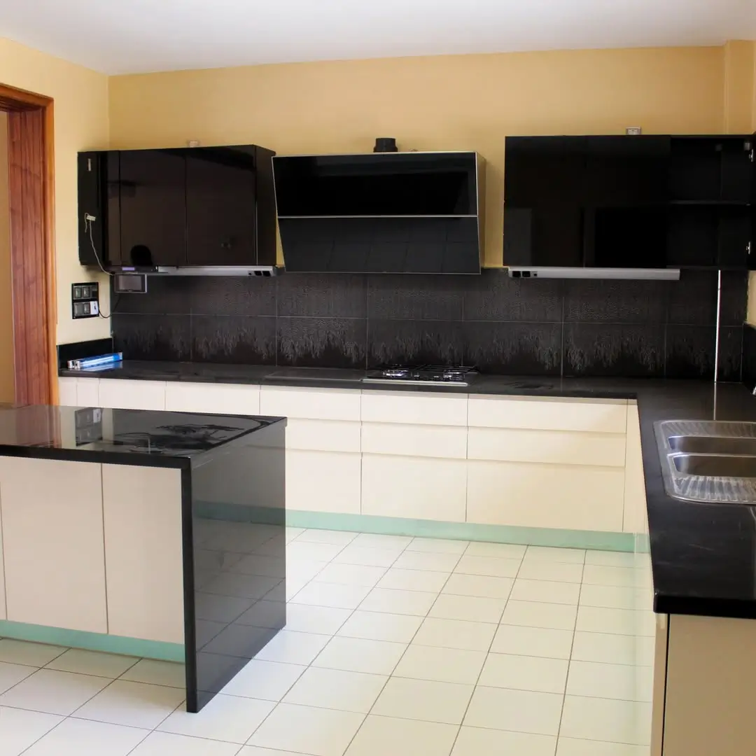 Modern kitchen with black backsplash, white cabinetry, island counter