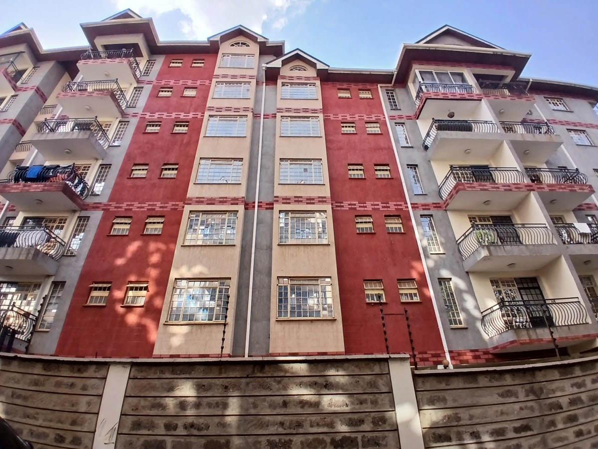 Multi-story residential building facade with red and beige paint