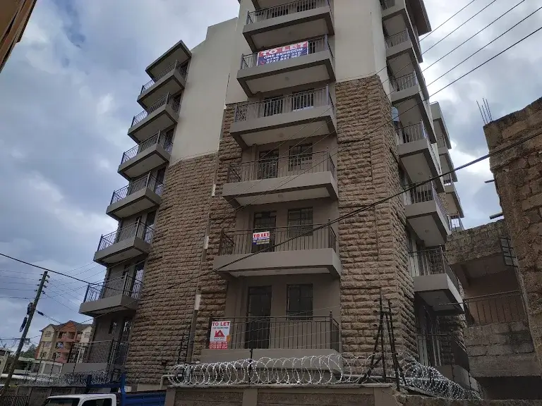 Multi-story residential building facade with stone cladding