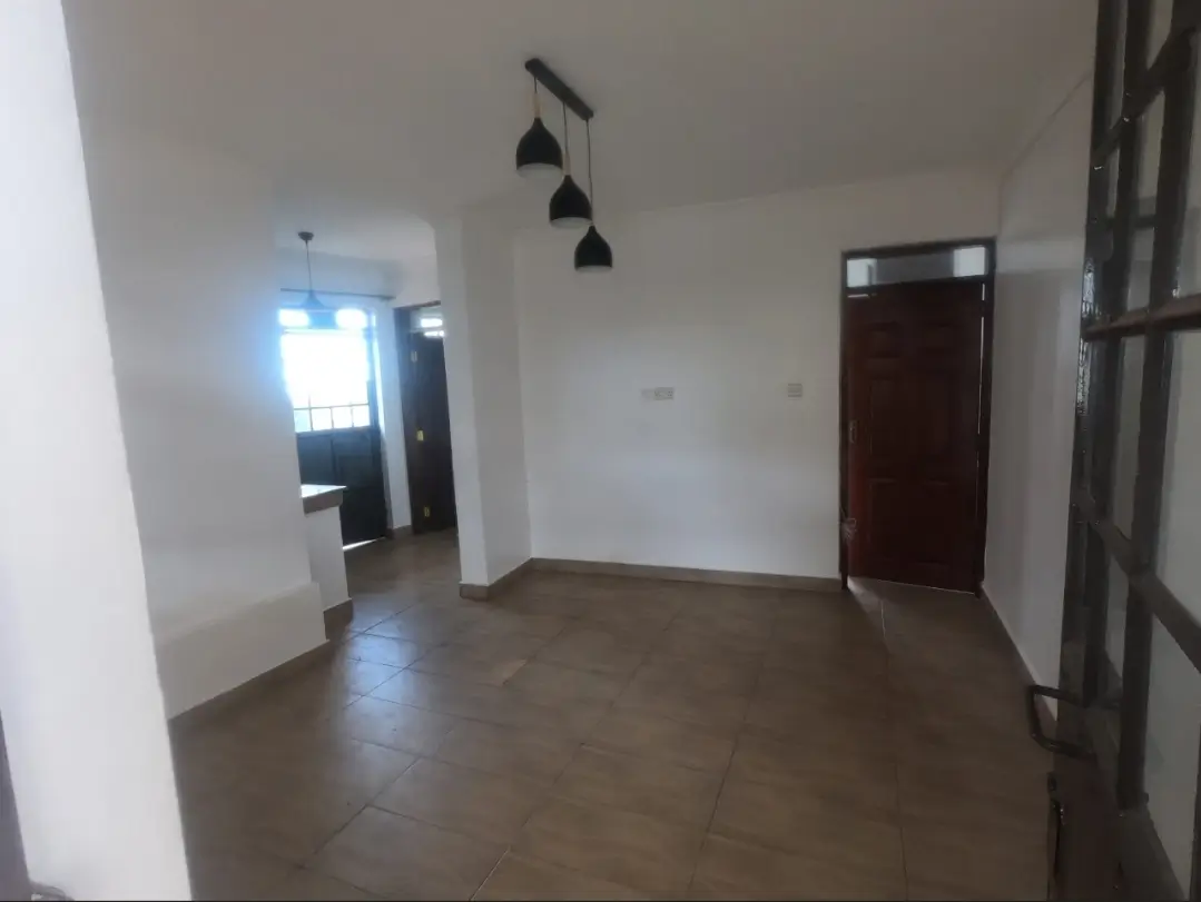 Spacious empty living room with pendant lighting and polished floors