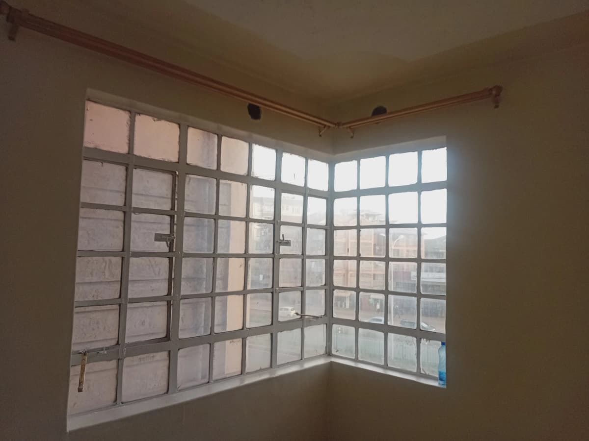 Interior view through large gridded windows overlooking urban landscape