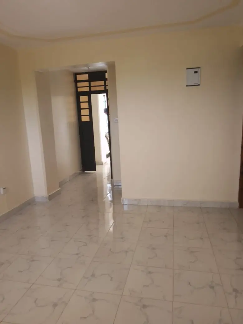 Empty living room with tiled floors and minimal furnishings
