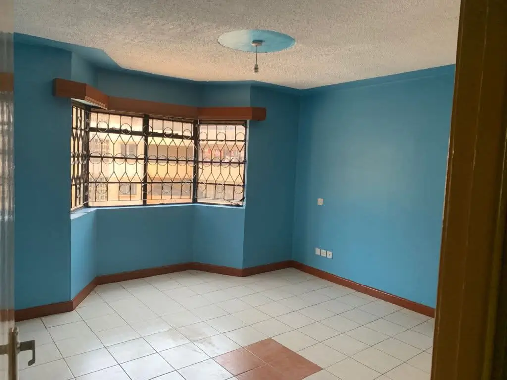 Bright blue living room with barred window and tiled flooring