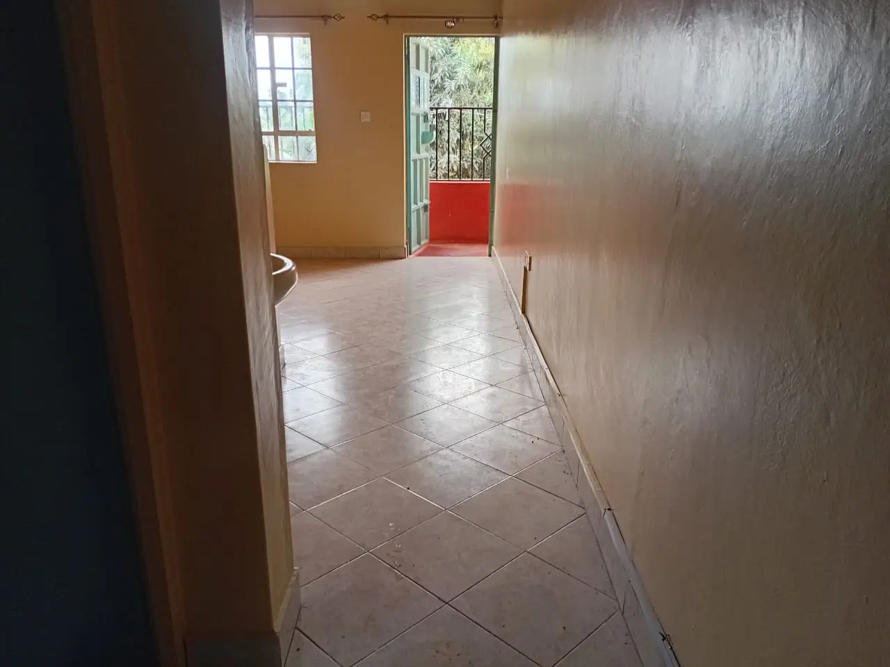 Bright corridor with tile flooring and balcony access