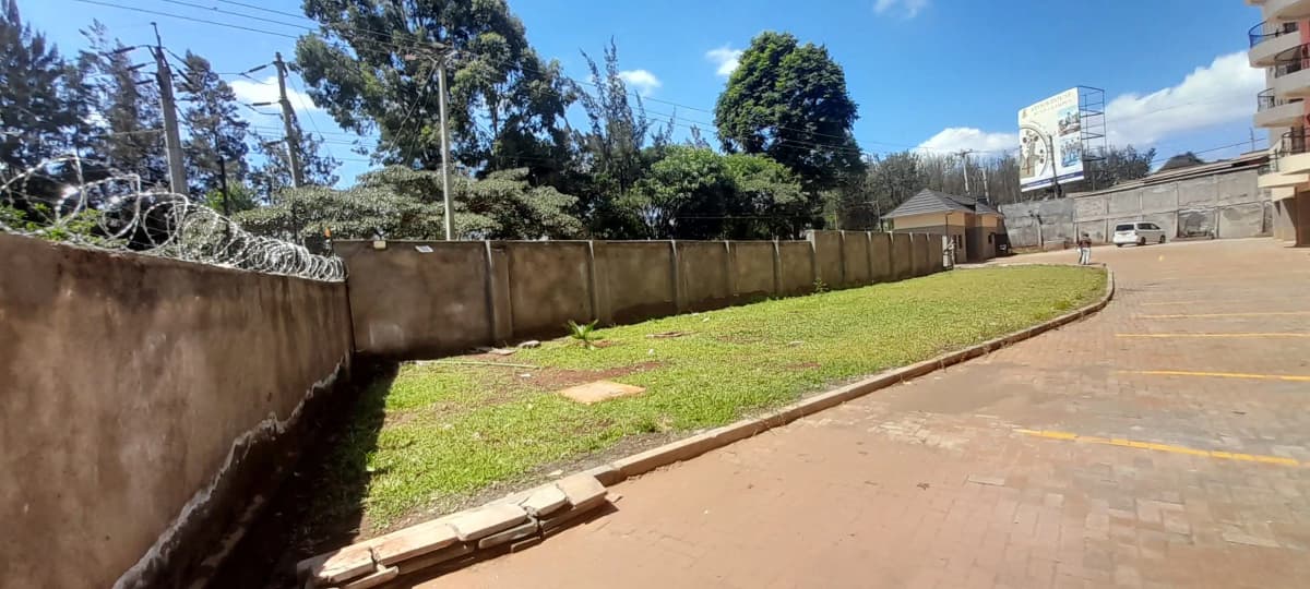 Spacious compound grounds with manicured lawn and perimeter wall