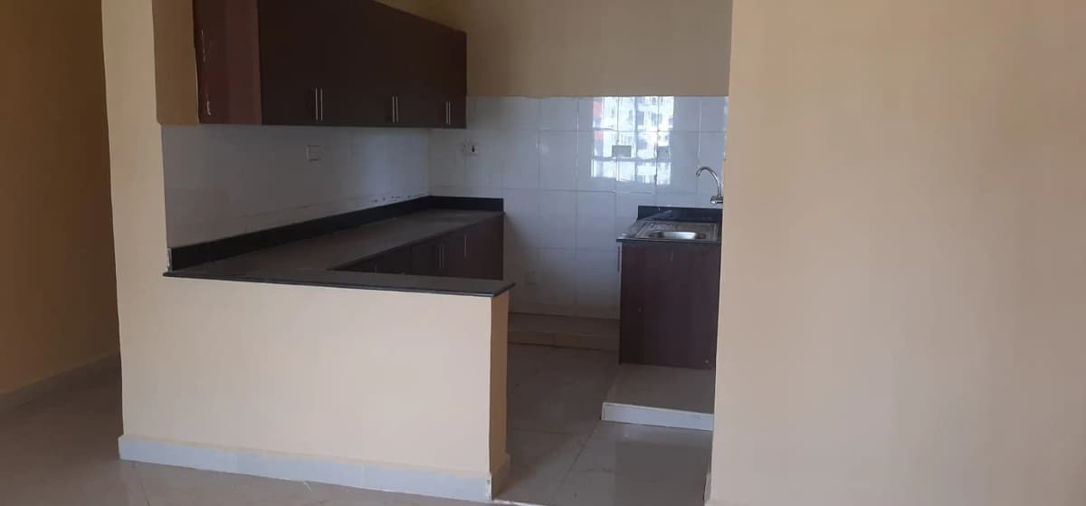 Open-plan kitchen with dark cabinetry and prep counter