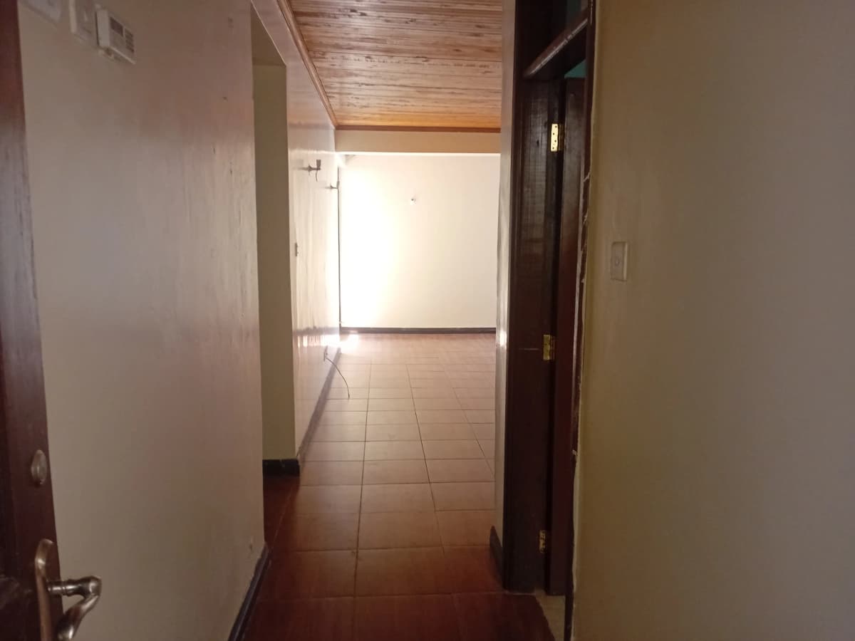 Corridor with wooden ceiling and terracotta tile flooring