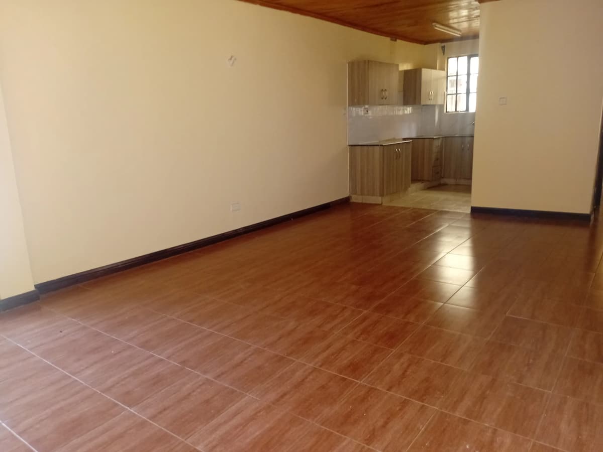 Open-plan living area with kitchen visible in background