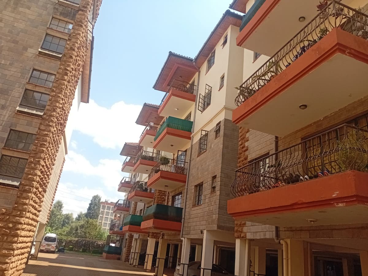 Multi-story residential building with colorful balconies and compound