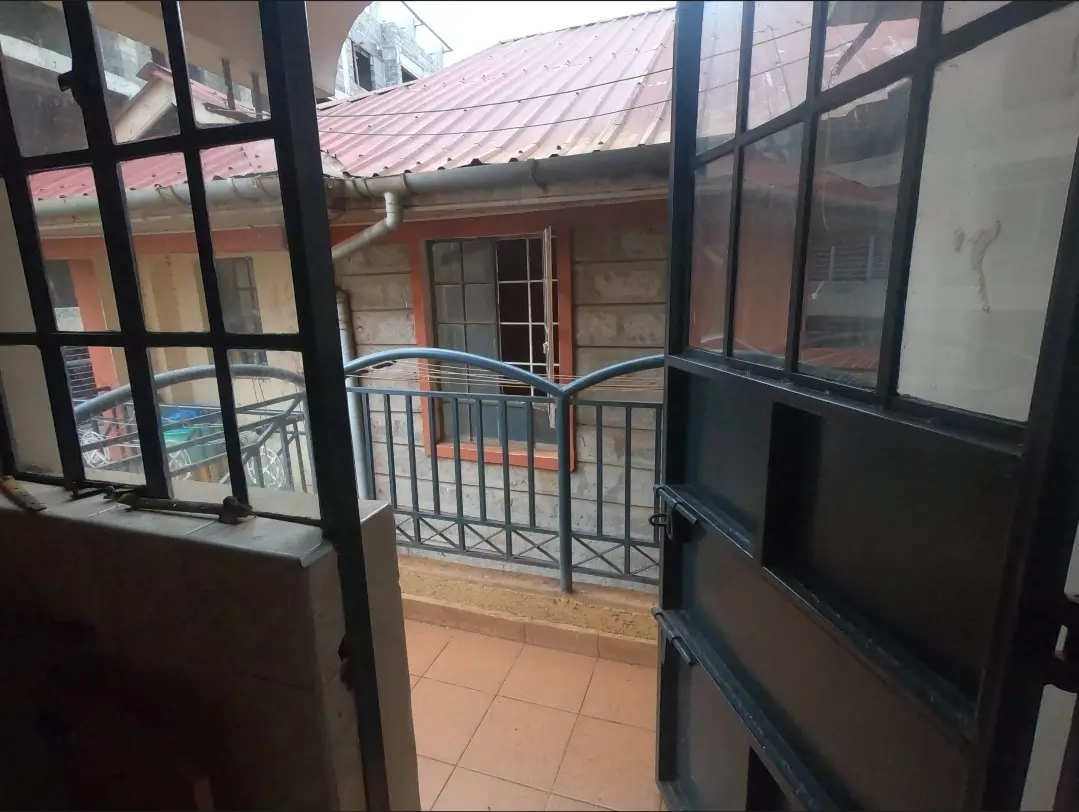 Balcony with metal railings overlooking compound grounds