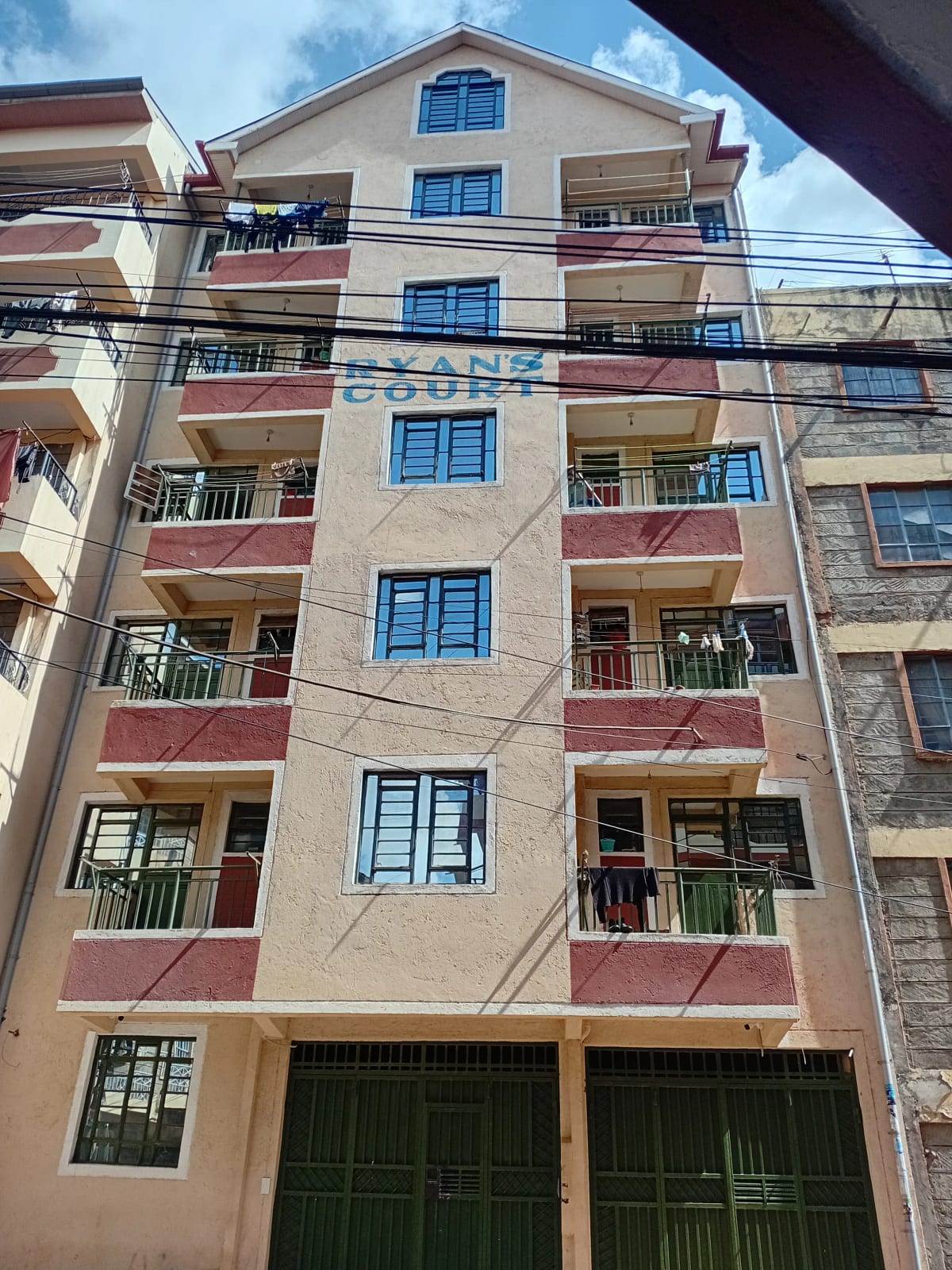 Multi-story residential building facade with balconies and ground parking