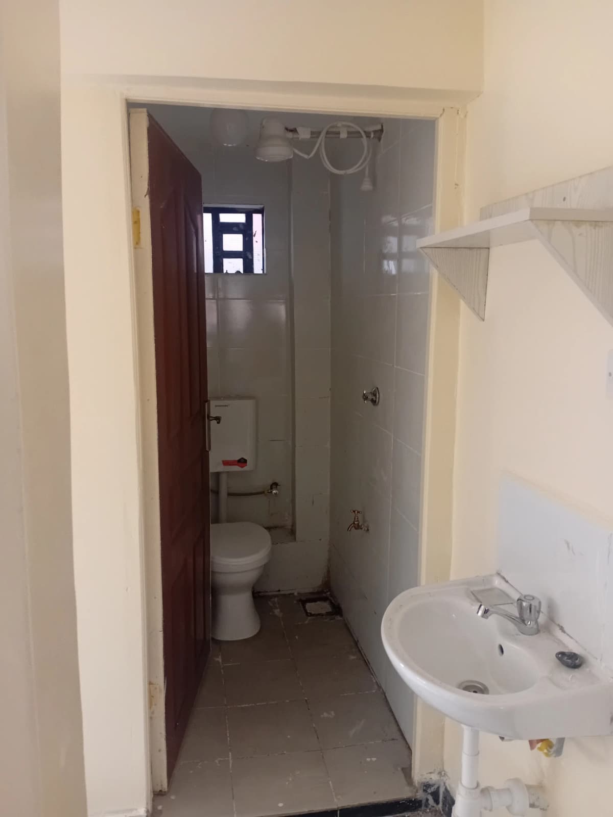 Compact bathroom with toilet, sink, and shower enclosure