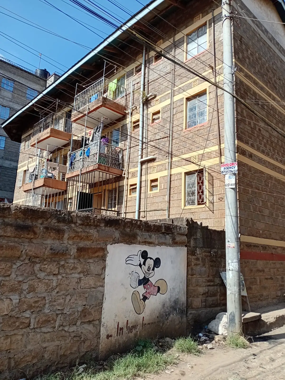 Multi-story residential building facade with balconies and brick wall