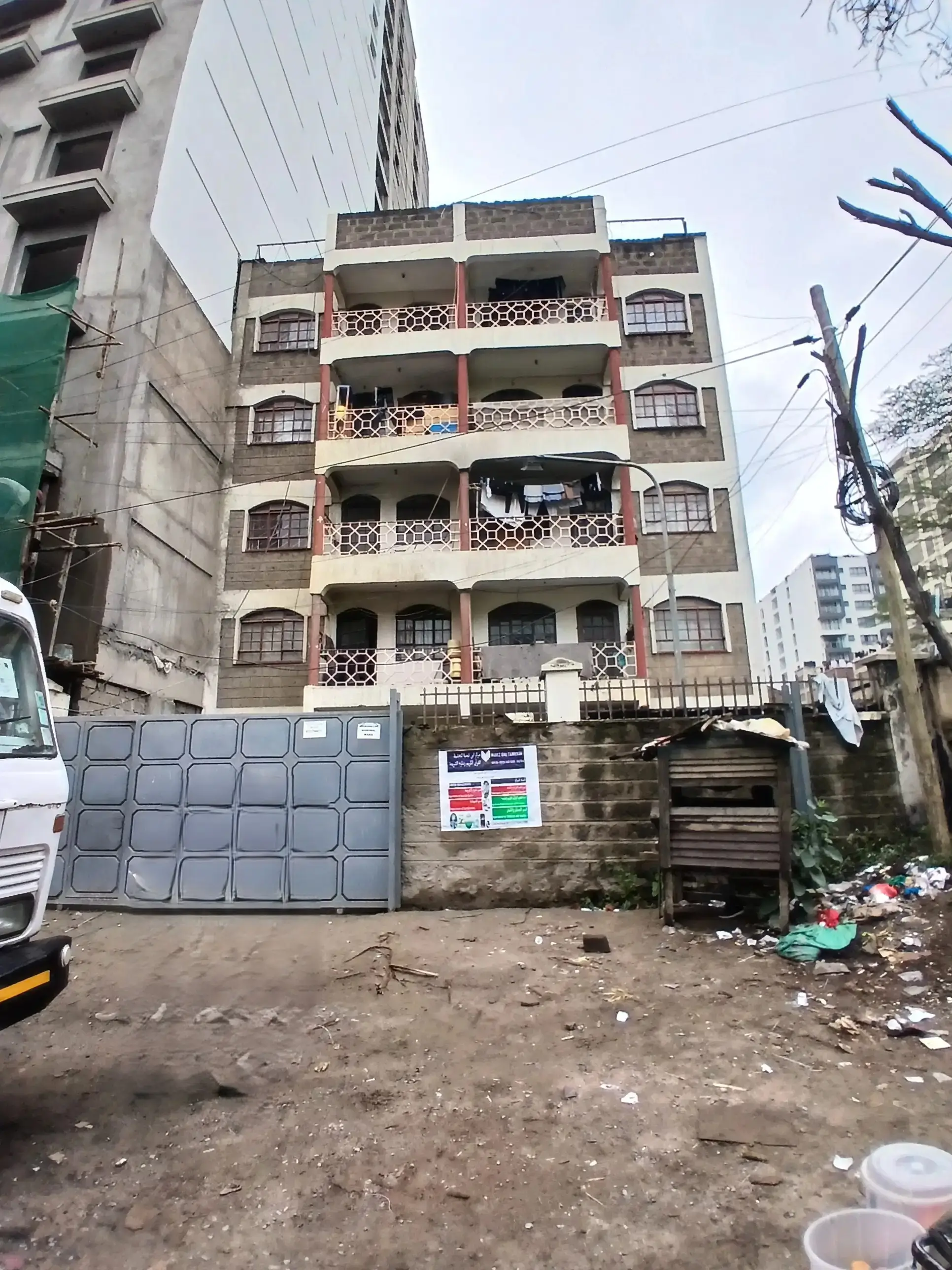 Multi-story residential building facade with balconies and ground parking