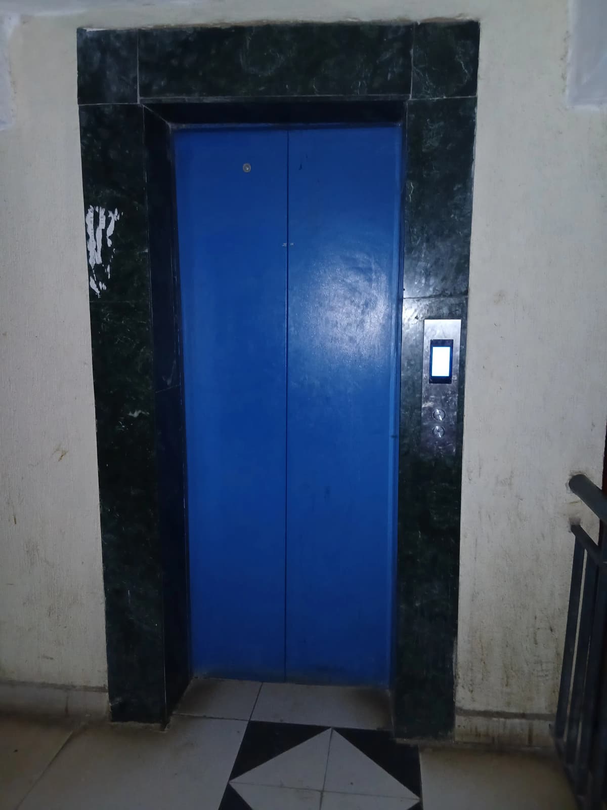 Building elevator with blue doors in lobby entrance