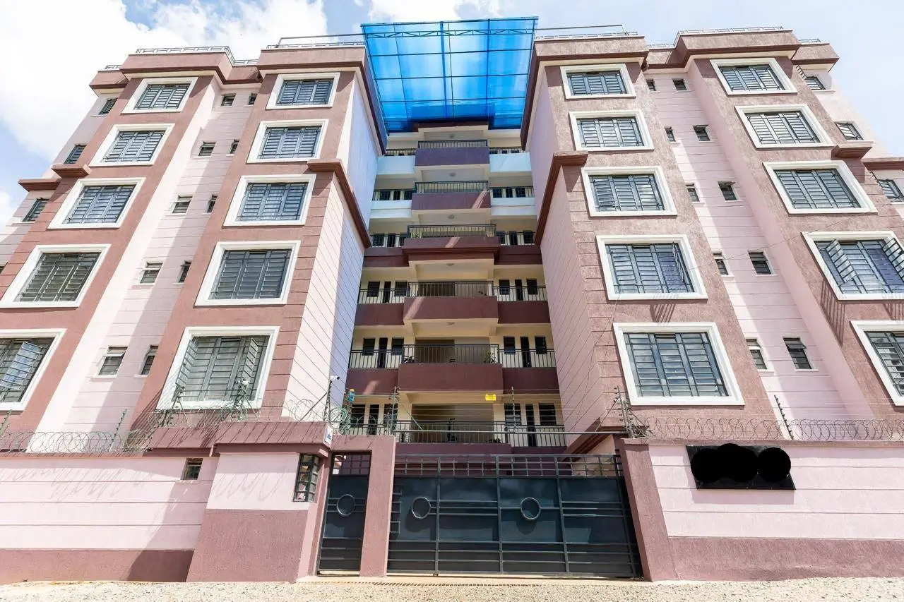 Multi-story residential building facade with pink walls and balconies