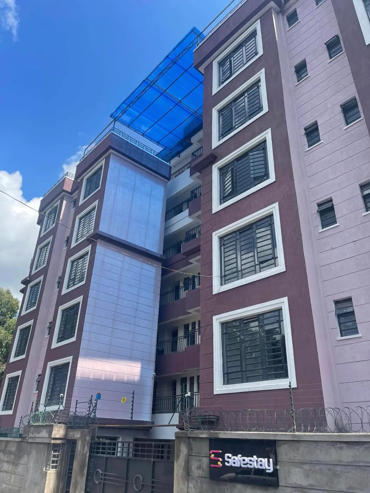 Modern multi-story residential building with glass and brick facade