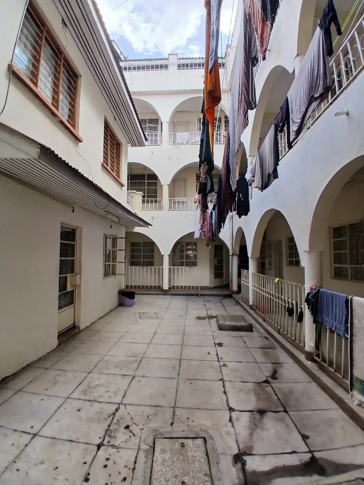 Multi-story courtyard with arched colonnade and tiled floors