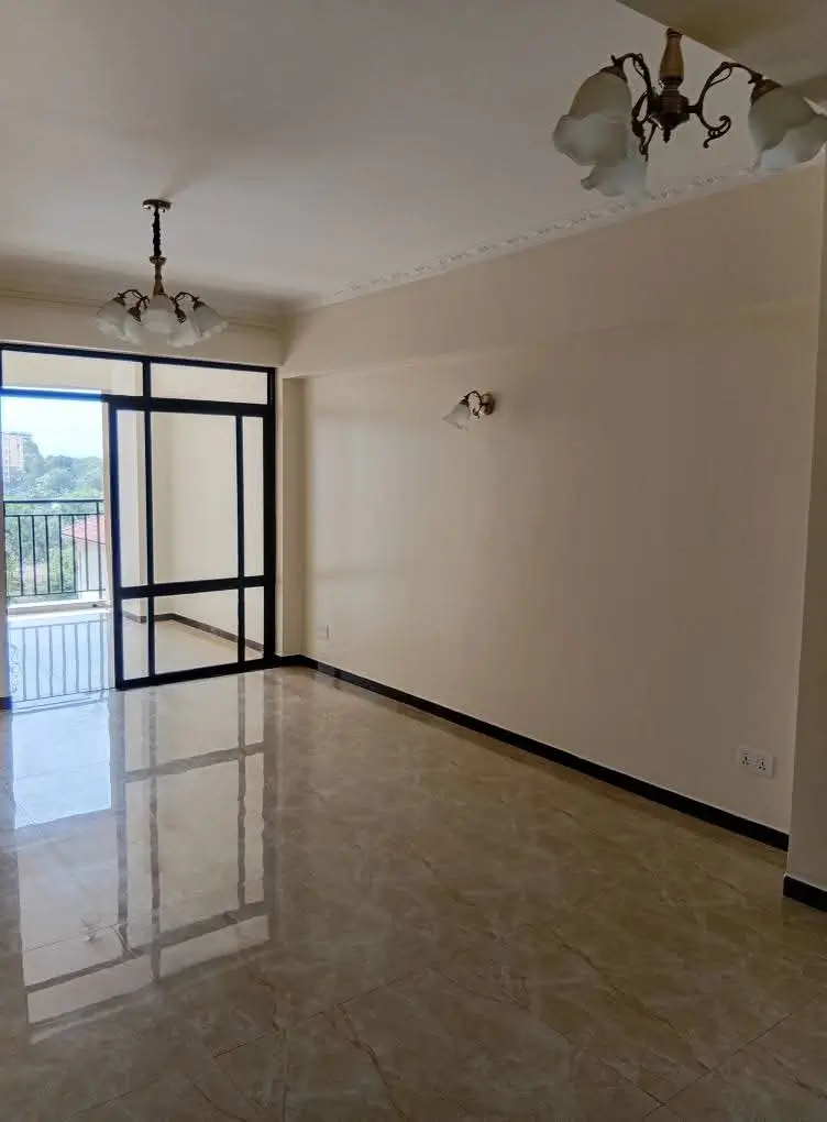 Spacious living room with polished floor and balcony access