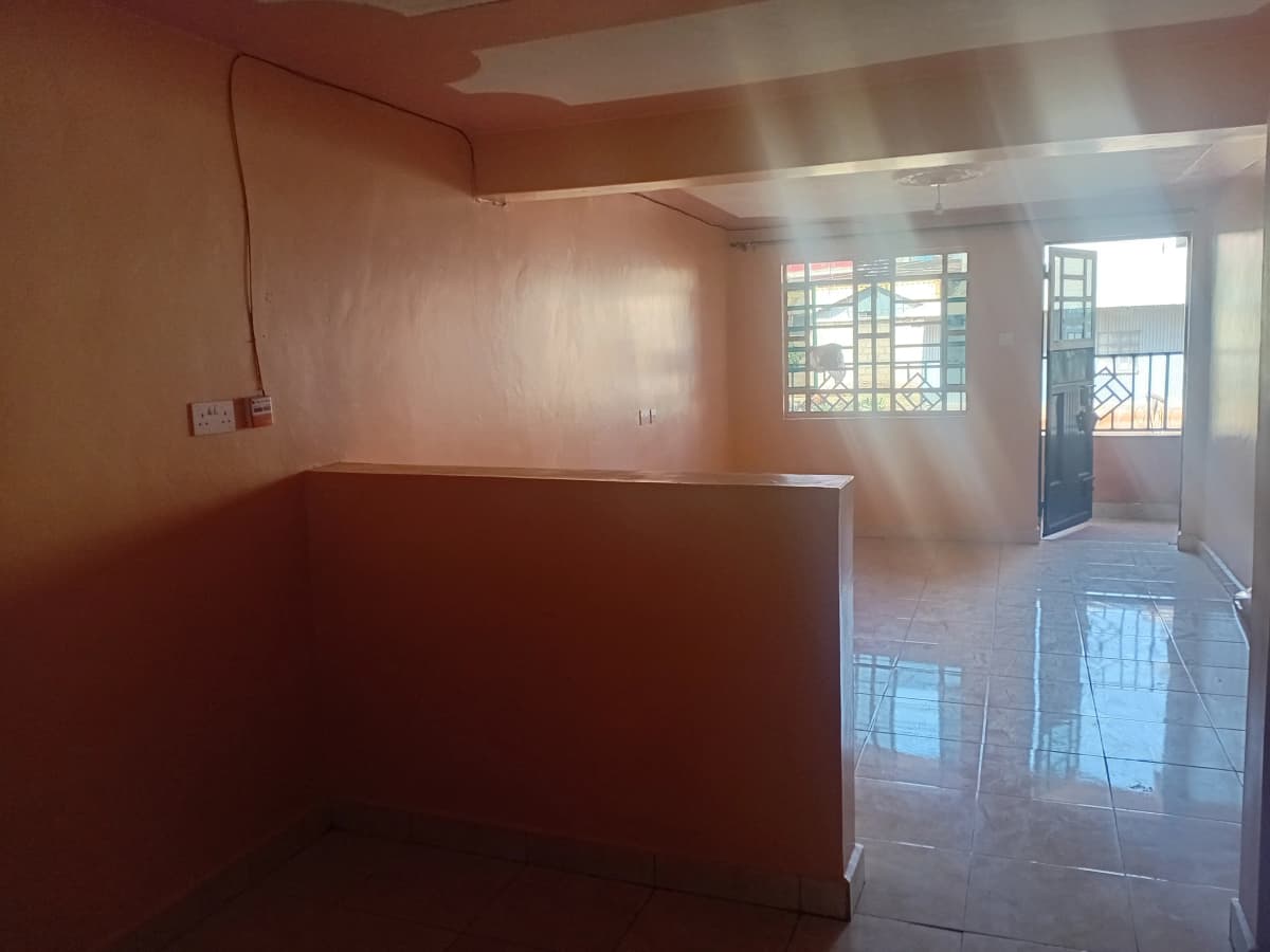 Empty living room with natural light from windows and balcony