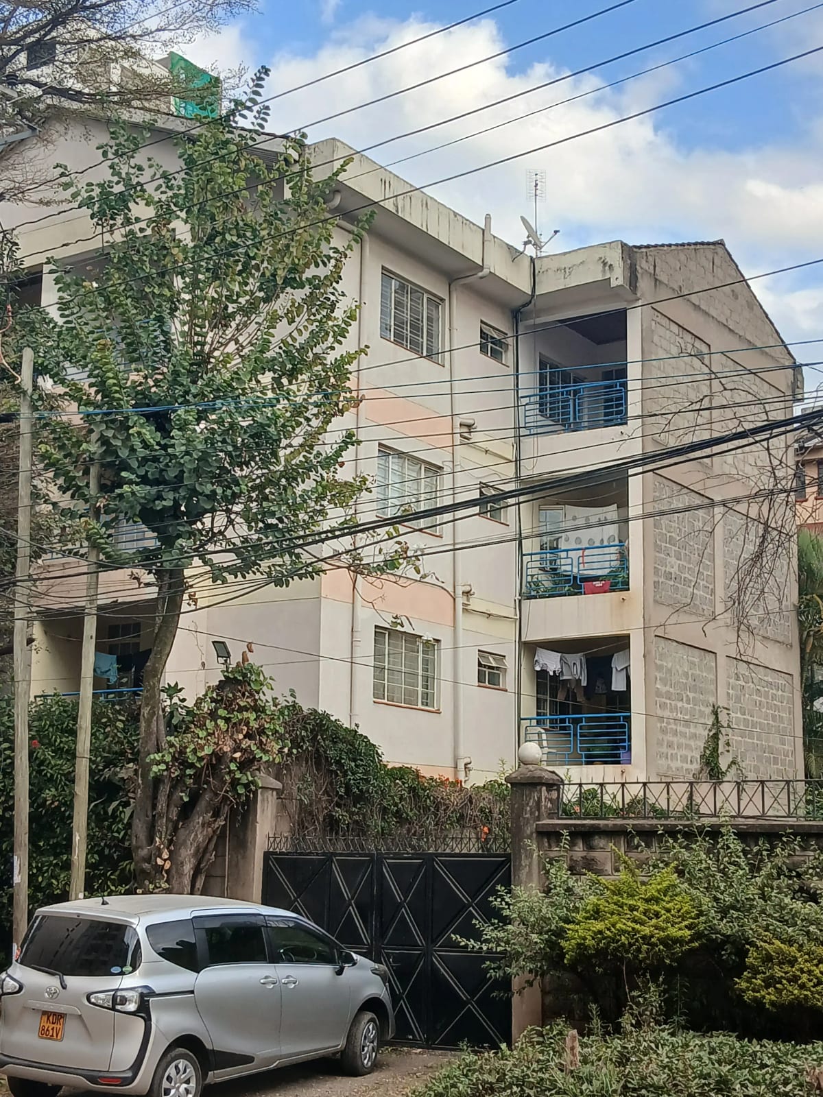 Multi-story residential building facade with parking below