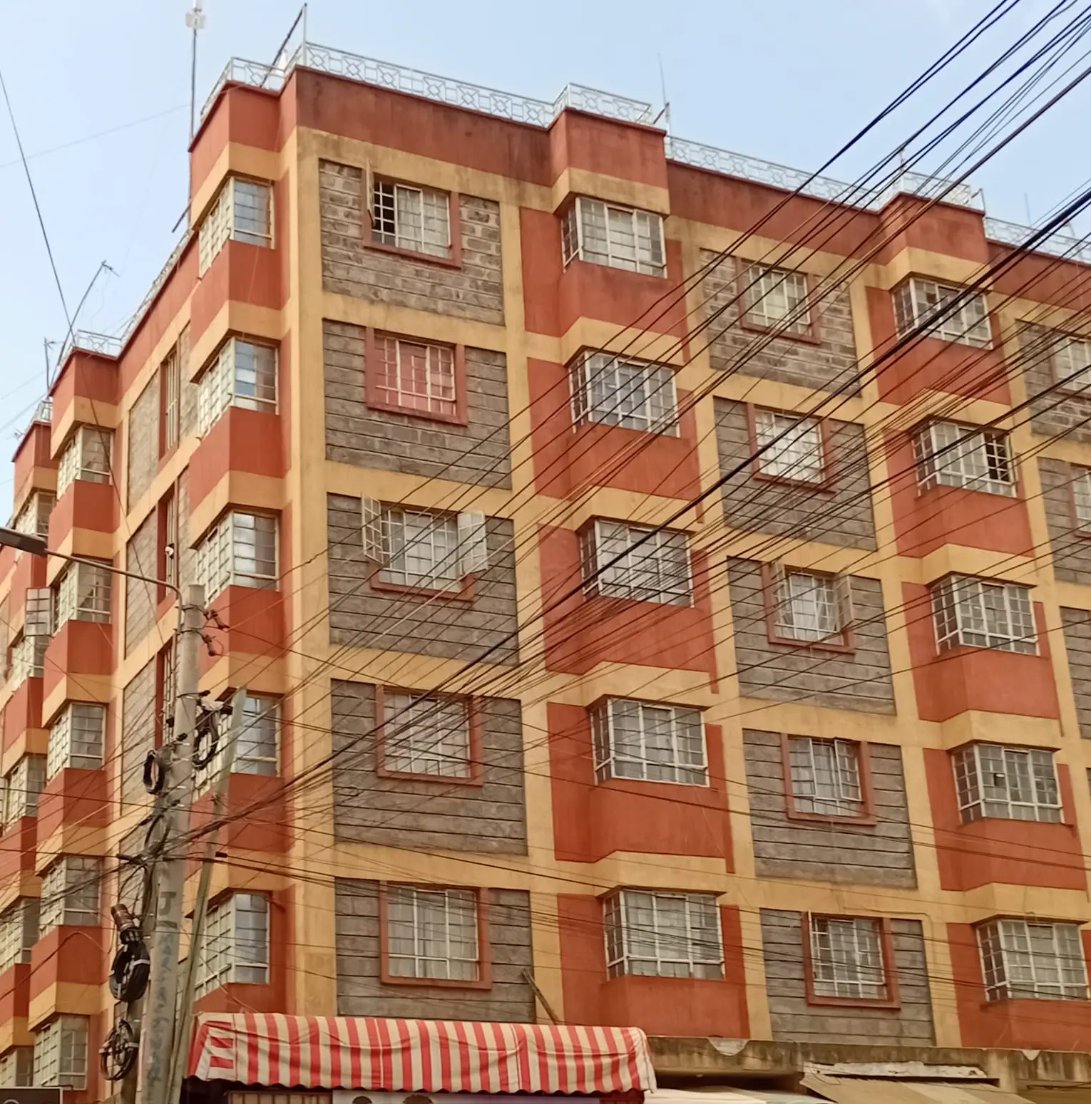 Orange and stone residential apartment building facade with security bars