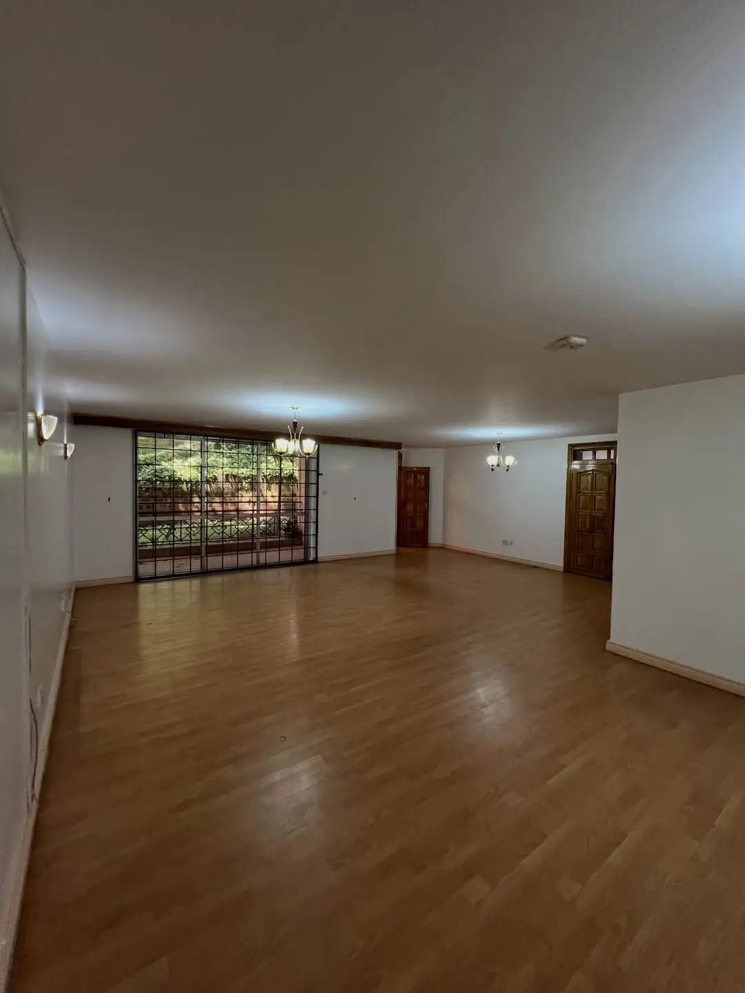 Spacious empty living room with wooden flooring and natural light