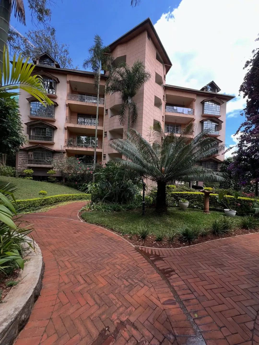 Sandalwood Apartments: Multi-story residential building with manicured compound and palm trees in Westlands