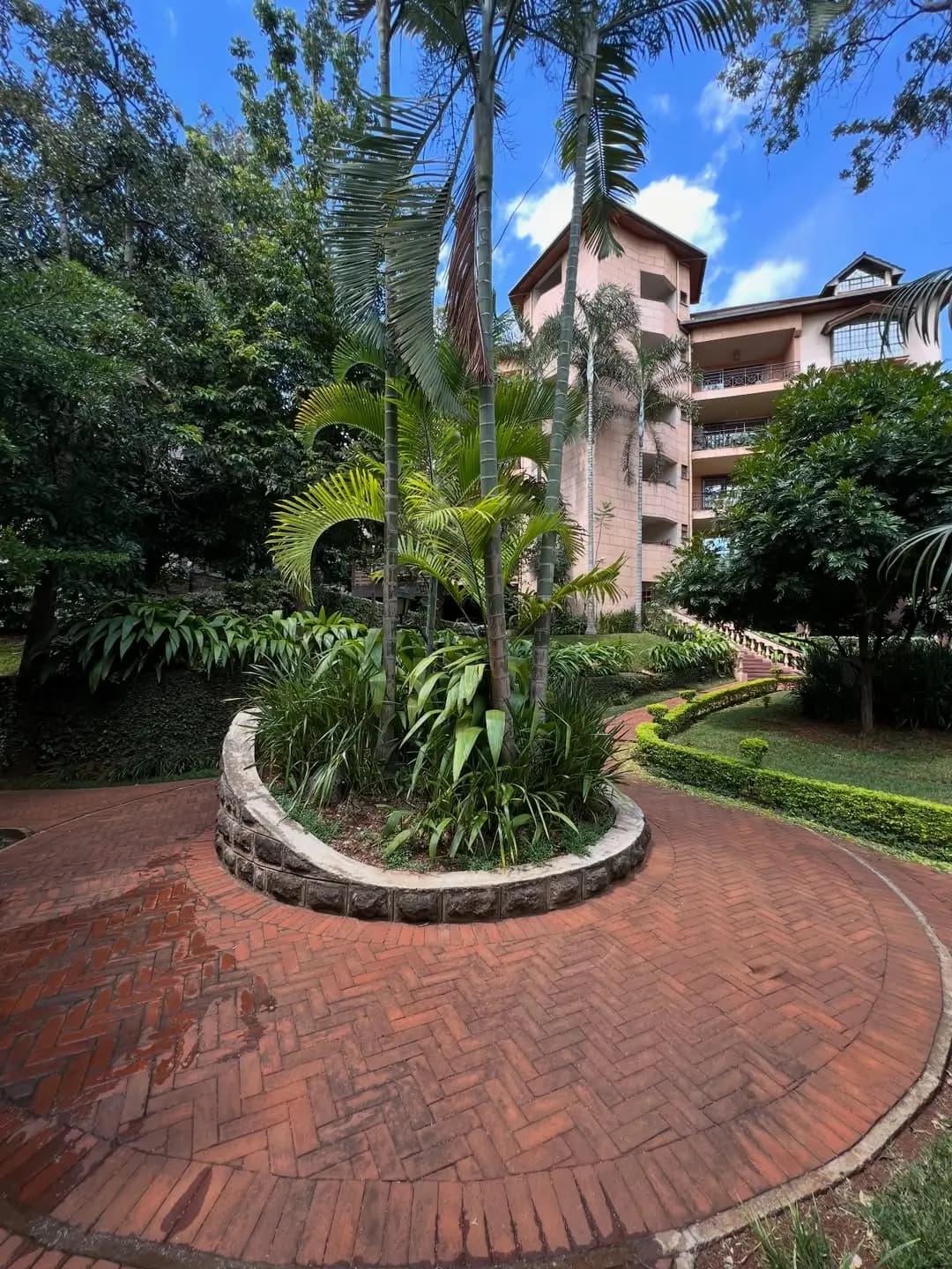 Landscaped compound with palm trees and brick paving