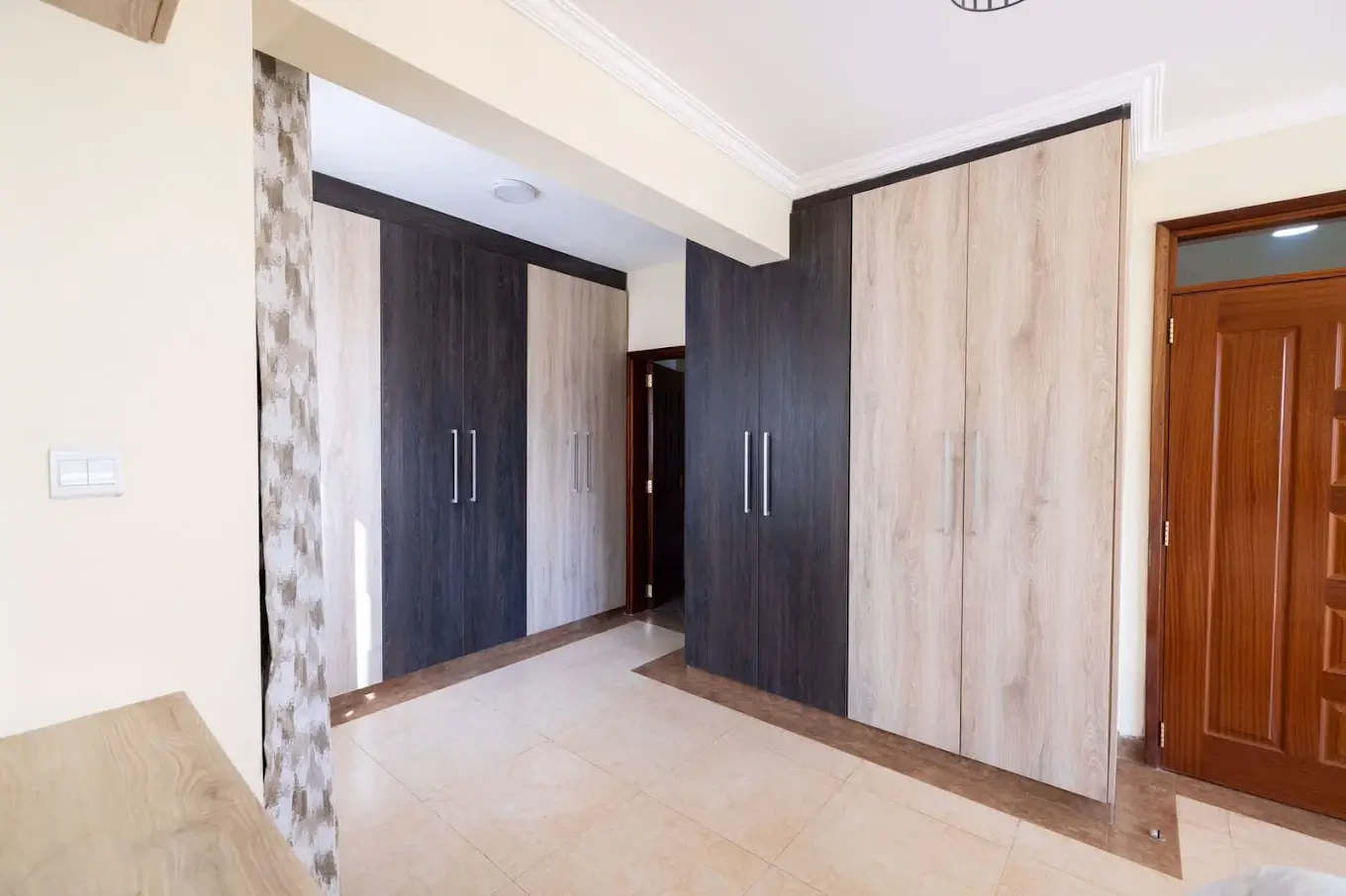 Spacious bedroom with built-in wardrobes and wooden door
