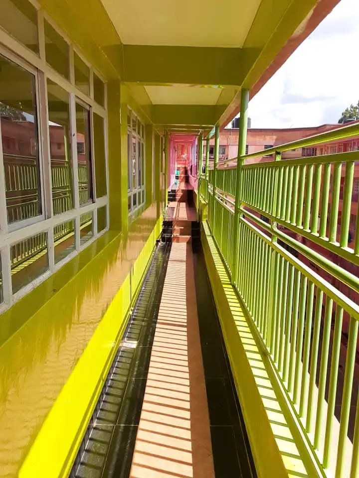 Bright lime-green covered balcony with metal railings and doors